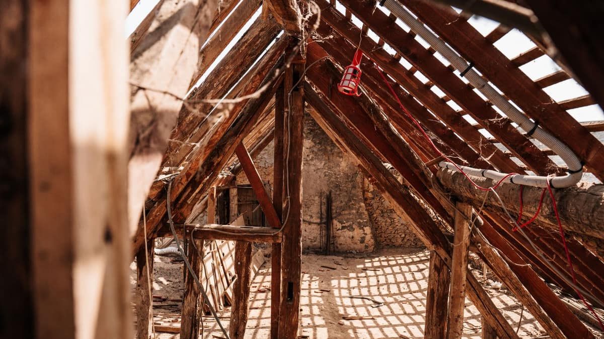 Exposed wooden roof rafters showing the rise and run used to work out roof pitch