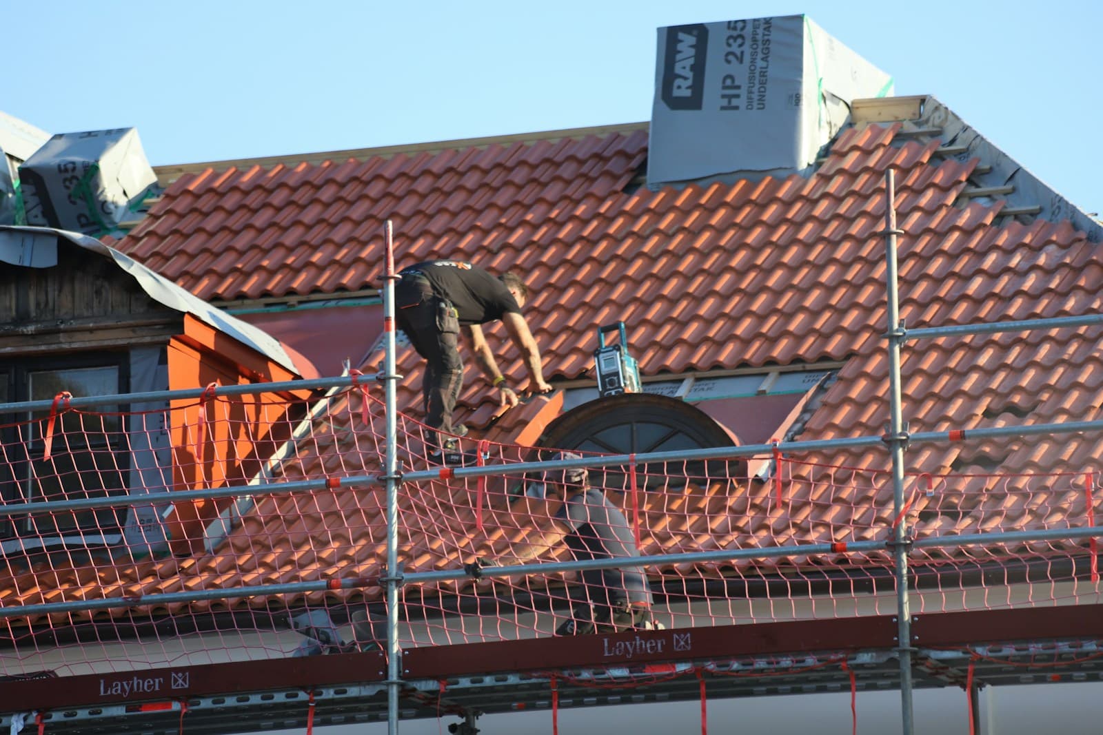Roofer assessing storm damage on a residential roof in the Texas hail corridor