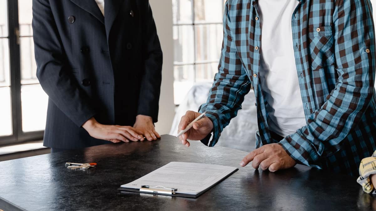 Homeowner reviewing a written roofing estimate at a table before choosing a roofer
